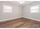 Bright bedroom features wood floors, neutral tones, and two windows at 7024 Rockledge Dr, Charlotte, NC 28210