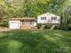 Charming two-story home with a well-manicured lawn and mature trees at 7024 Rockledge Dr, Charlotte, NC 28210