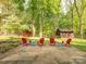 Outdoor patio with chairs and tables surrounded by lush greenery and mature trees at 7024 Rockledge Dr, Charlotte, NC 28210