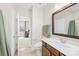 View of a bathroom that leads into a bedroom with a sink, toilet, and wood-trimmed mirror at 705 Brown Creek Dr, Matthews, NC 28104