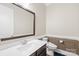 Elegant half bathroom featuring a modern toilet, stylish vanity and decorative wainscoting at 705 Brown Creek Dr, Matthews, NC 28104