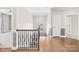 Upstairs hallway featuring hardwood floors, staircase with wrought iron railing, and natural light at 705 Brown Creek Dr, Matthews, NC 28104
