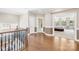 Second floor hallway showcasing hardwood floors, a staircase with wrought iron railing, and bedroom entrances at 705 Brown Creek Dr, Matthews, NC 28104
