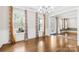 Bright living room with hardwood floors, wainscoting, and large windows with patterned curtains at 705 Brown Creek Dr, Matthews, NC 28104