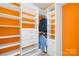 Organized walk-in closet with white shelving and orange accent walls at 705 Brown Creek Dr, Matthews, NC 28104