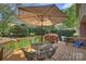 Inviting outdoor deck with a dining set, umbrella, and lush green backyard at 7117 Chadwyck Farms Dr, Charlotte, NC 28226