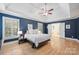 Spacious bedroom with a ceiling fan, hardwood floors, trey ceilings, and access to the main bathroom at 7117 Chadwyck Farms Dr, Charlotte, NC 28226