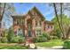 Charming brick home with arched entry, well-maintained lawn, and mature trees at 7117 Chadwyck Farms Dr, Charlotte, NC 28226