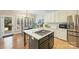 Modern kitchen with center island, stainless appliances, hardwood floors, and breakfast nook at 7117 Chadwyck Farms Dr, Charlotte, NC 28226