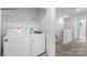Bright laundry room with a white washer and dryer, overhead shelving, and access to the hallway at 729 Wagon Cross Ct, York, SC 29745