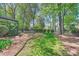 Well maintained backyard with mature trees, lush landscaping, and a cozy hammock at 7316 Versailles Ln, Charlotte, NC 28277