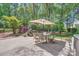 Backyard patio with dining and grilling area plus lush landscaping and mature trees at 7316 Versailles Ln, Charlotte, NC 28277