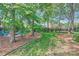 Lush backyard featuring mature trees, well manicured lawn and manicured flowerbeds at 7316 Versailles Ln, Charlotte, NC 28277