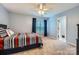 Comfortable bedroom boasts soft blue walls, plush carpeting, and an attached bathroom for added privacy at 7316 Versailles Ln, Charlotte, NC 28277