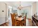 Dining room featuring wood table and chairs, chandelier, and natural light at 7316 Versailles Ln, Charlotte, NC 28277