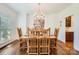 Dining room features a wood table with seating for six under a chandelier, with views to the kitchen at 7316 Versailles Ln, Charlotte, NC 28277