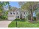 Charming two-story home with a manicured lawn, mature trees, and a two-car garage at 7316 Versailles Ln, Charlotte, NC 28277
