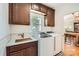 Well-lit laundry room with modern washer and dryer, custom cabinets, and a sink for added convenience at 7316 Versailles Ln, Charlotte, NC 28277