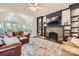 Cozy living room featuring a stone fireplace, built-in bookshelves, and a leather sectional at 7316 Versailles Ln, Charlotte, NC 28277