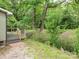 Landscaped backyard with a small wood deck, gravel area and mature trees at 803 E 13Th St, Kannapolis, NC 28083