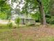 Backyard view of the home showing the back deck, green siding, and lush landscaping at 803 E 13Th St, Kannapolis, NC 28083