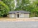 Charming one-story home with green siding, a new roof, white trim and a cozy front porch surrounded by mature trees at 803 E 13Th St, Kannapolis, NC 28083
