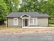 Charming single-story home with light green siding, black front door, and well-maintained yard with small decorative fence at 803 E 13Th St, Kannapolis, NC 28083