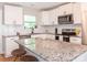 Modern kitchen with white cabinetry, subway tile backsplash, stainless steel appliances, and a granite-topped island at 803 E 13Th St, Kannapolis, NC 28083