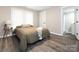 Serene main bedroom with neutral walls, wood-look floors, a bright window, and a door to the bathroom at 803 E 13Th St, Kannapolis, NC 28083