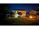 A beautiful backyard at night featuring a fire pit, well-manicured lawn, and patio for relaxing and entertaining at 8140 Laurel Run Dr, Charlotte, NC 28269