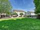 Expansive backyard featuring a well-kept lawn, patio area, and mature trees, perfect for outdoor activities and gatherings at 8140 Laurel Run Dr, Charlotte, NC 28269