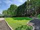 Lush backyard with well-maintained lawn, complemented by decorative stone and mulch beds, offering a serene outdoor space at 8140 Laurel Run Dr, Charlotte, NC 28269
