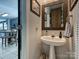 Stylish half bath featuring modern fixtures, a pedestal sink, and tasteful decor, conveniently located near the kitchen at 8140 Laurel Run Dr, Charlotte, NC 28269