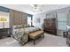 Inviting primary bedroom features a decorative wood accent wall, ceiling fan, and ample natural light at 8140 Laurel Run Dr, Charlotte, NC 28269