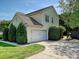 Home featuring a well-manicured lawn, mature trees, and a two-car garage, providing ample space and curb appeal at 8140 Laurel Run Dr, Charlotte, NC 28269