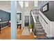 Inviting foyer with hardwood floors, a staircase, and access to a home office creating a bright and open entryway at 8140 Laurel Run Dr, Charlotte, NC 28269