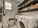 Functional laundry room with modern washer and dryer and shelving for storage solutions at 8140 Laurel Run Dr, Charlotte, NC 28269