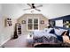Bedroom with a ceiling fan, neutral walls and dark blue accent wall and a large window with backyard view at 1016 Secretariat Dr, York, SC 29745