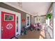 Inviting front porch with seating, plants, and a charming red door, enhancing curb appeal at 1016 Secretariat Dr, York, SC 29745