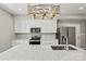 Modern kitchen with white cabinets, stainless steel appliances, and a decorative light fixture above the island at 102 Kerda St, Taylorsville, NC 28681