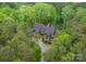 Luxurious home with stone and wood design, nestled among lush trees, boasting a sprawling driveway at 10723 Green Heron Ct, Charlotte, NC 28278