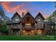 Expansive home showcasing a stone and wood facade with a covered patio, balcony, and beautiful backyard at 10723 Green Heron Ct, Charlotte, NC 28278