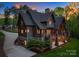 An exterior view of a gorgeous luxury home with a wood and stone facade and spacious balcony at 10723 Green Heron Ct, Charlotte, NC 28278