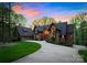 Stunning exterior of a multi-story home featuring a stone facade, timber accents, and a circular driveway at 10723 Green Heron Ct, Charlotte, NC 28278
