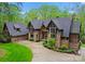 Stunning home displaying beautiful stonework, wood accents, a sprawling lawn, and an expansive driveway at 10723 Green Heron Ct, Charlotte, NC 28278