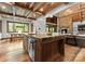 Open-concept kitchen with a large island, wood beams, stone accents, and a seamless connection to the dining area at 10723 Green Heron Ct, Charlotte, NC 28278