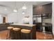 Open kitchen with stainless appliances, island seating, stone countertops, and view of living area at 10723 Green Heron Ct, Charlotte, NC 28278