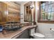 Chic powder room boasts a wood accent wall, vessel sink, and wood countertop at 10723 Green Heron Ct, Charlotte, NC 28278