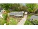 An aerial view shows the home, with a screened-in porch and driveway, on a well-manicured lawn and landscaping at 1113 Urban Pl, Charlotte, NC 28209