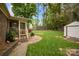 Spacious backyard with a screened porch, storage shed, and mature trees at 1113 Urban Pl, Charlotte, NC 28209